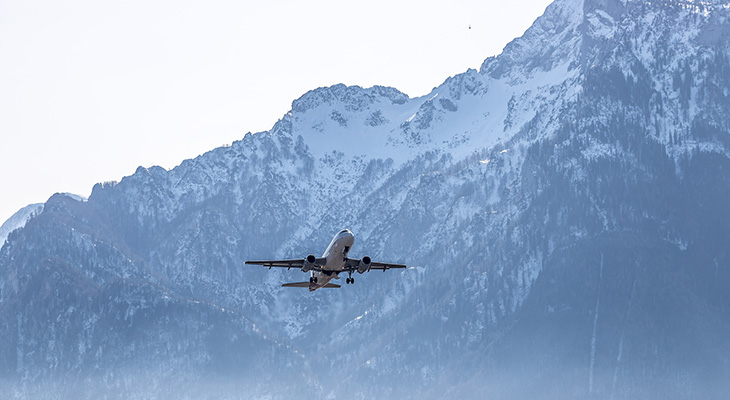 Aereo in volo e montagne sullo sfondo